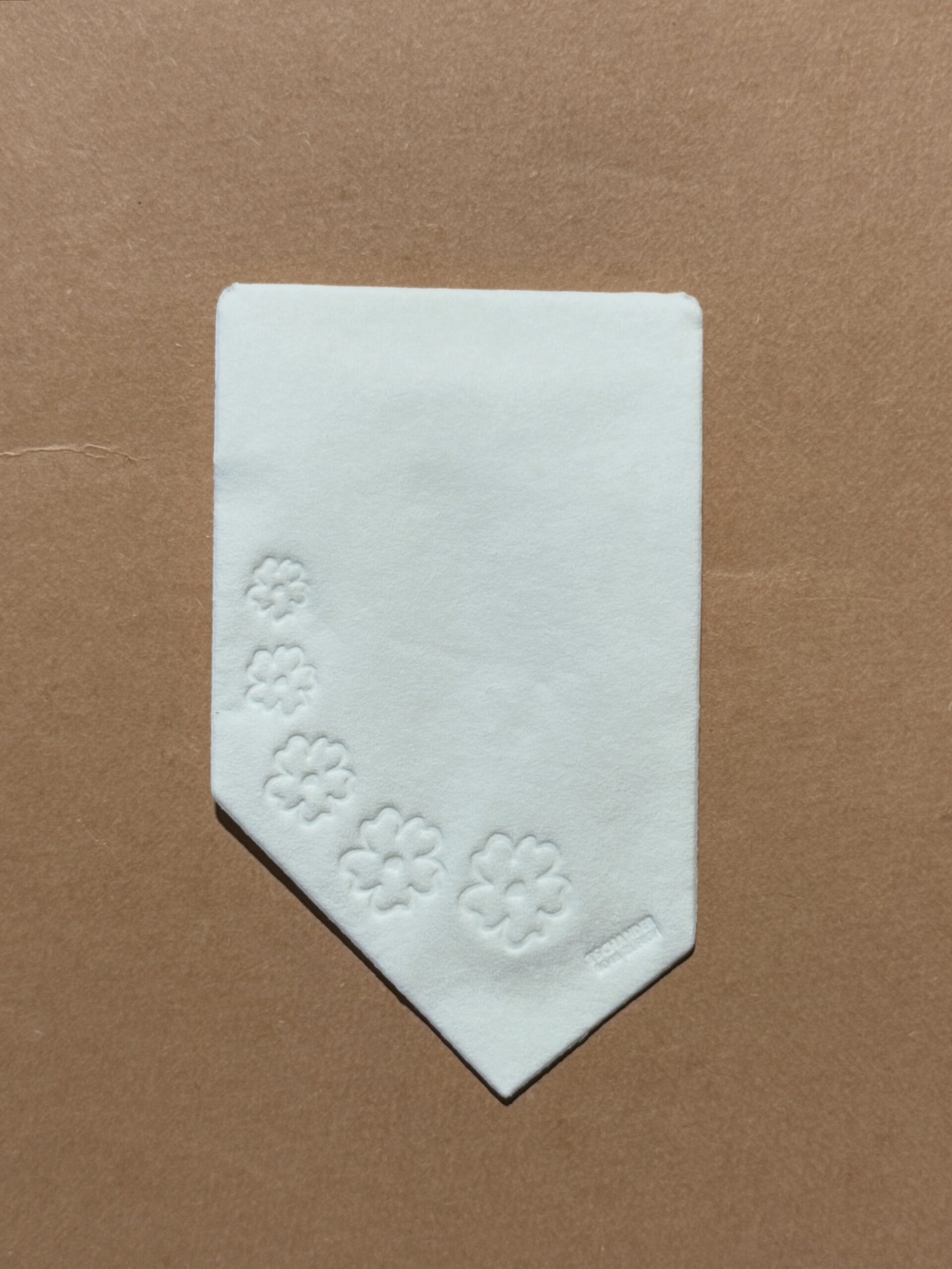 Asymetrical napkin with flowers embossed