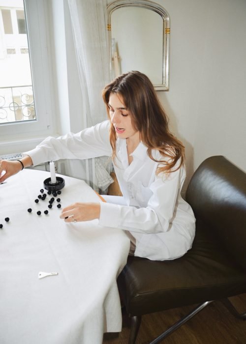 young woman spilling beads on table